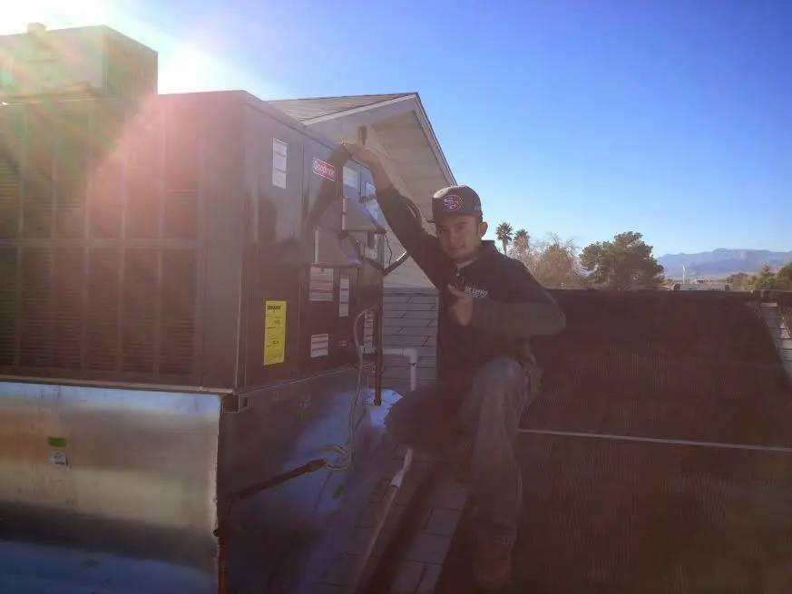 HVAC technician performing AC Tune-Up on a rooftop unit in Youngstown